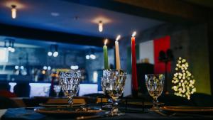 巴库里阿尼Hotel Sapphire Bakuriani的一张桌子,上面放着四杯和蜡烛