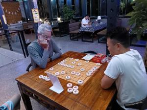 重庆阅江老院青年旅舍(重庆解放碑店)的坐在桌边玩棋盘游戏的两个人