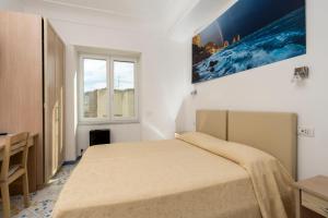 卡普里拉皮亚泽塔旅馆的白色的卧室设有床和窗户