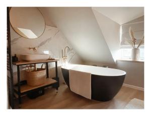 托伦Slapen op Tholen的浴室配有大浴缸和水槽