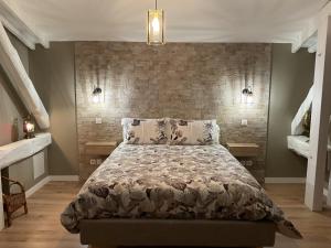 艾克斯莱班LA MANSARDE的一间卧室设有一张床和砖墙