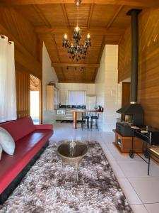 阿尔弗雷多瓦格内尔Aconchego Alto da Serra的客厅配有红色的沙发和桌子