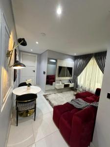 莱基KADAL IN LEKKI的客厅配有红色的沙发和桌子