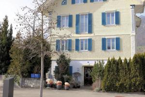 AlpnachGerlis - relaxte Ferien in typischem Dorfhaus的一座大型建筑,上面有蓝色百叶窗