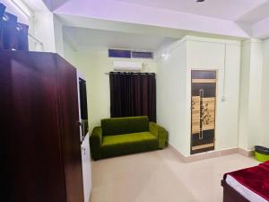 TezpurJM Suites的一间客厅,客厅里摆放着绿椅