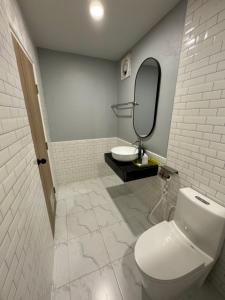 武里南S1 City Hotel Buriram的一间带卫生间、水槽和镜子的浴室
