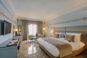 马拉喀什Grand Mogador Menara & Spa的酒店客房设有一张大床和一台电视。