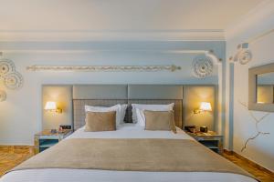 马拉喀什Grand Mogador Menara & Spa的一间卧室配有一张大床和两张桌子