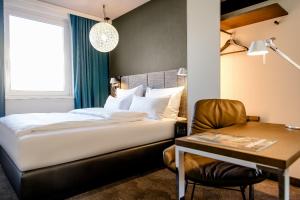 纽伦堡纽伦堡1号汽车酒店的一间卧室配有一张床、一张桌子和一把椅子