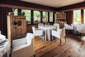 圣格特鲁德瓦尔德阿尔提莫Haus Elisabeth的餐厅设有白色的椅子和桌子以及窗户。