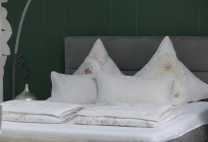 哈恩Prinz Ole的一张带白色枕头和绿色墙壁的床