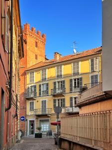 阿斯蒂Il Bumbunin Esclusivo monolocale nel cuore di Asti的带阳台的黄色建筑,砖砌建筑
