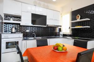 伏罗拉Rezidenca Panorama Apartments的厨房里放着一碗水果放在桌子上