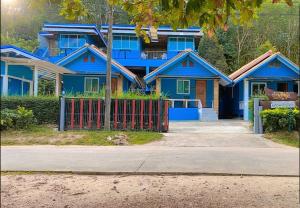 阁遥岛Ban Tidlay - SHA的前面有红墙的蓝色房子