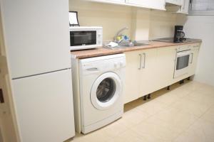 坎德拉里亚Apartamento LiLi Beach的厨房配有洗衣机和微波炉。