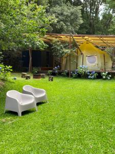 维亚纳堡Wild Glamping Portugal的一个带两把白色椅子和帐篷的庭院