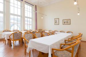萨斯尼茨萨斯尼茨库恩酒店的一间设有白色桌椅的用餐室