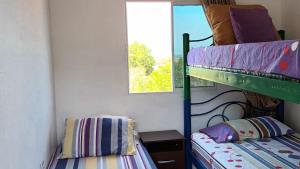 TubaráCabaña frente a la playa的一间卧室配有双层床和窗户。