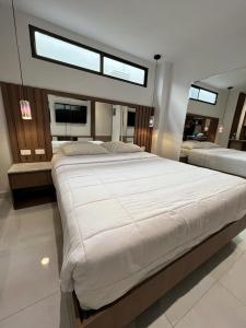 瓜亚基尔NOVAPARK HOTEL的卧室配有一张大白色床和窗户