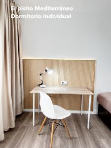 梅利利亚El pisito mediterráneo的一张带椅子和灯的白色书桌