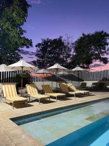 吉拉尔多特Hotel San German的一组椅子和遮阳伞,位于游泳池旁