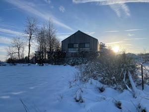 巴特明斯特艾弗尔Eifelhaus UT Mutscheid的雪地中带太阳的房屋
