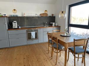 巴特明斯特艾弗尔Eifelhaus UT Mutscheid的厨房铺有木地板,配有木桌。