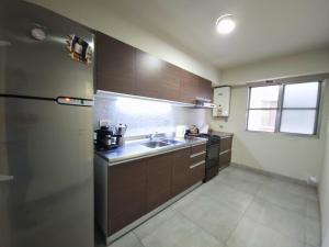 圣达菲Amplio departamento céntrico a 2 cuadras de la peatonal的厨房配有水槽和冰箱