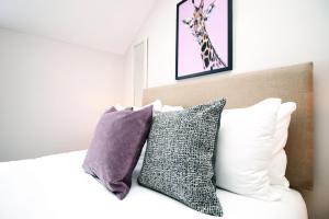 卡迪夫Stay with Free Parking at Archer Road Penarth的一间卧室配有一张带枕头的床和长颈鹿图