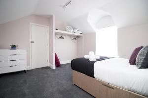卡迪夫Stay with Free Parking at Archer Road Penarth的卧室配有白色的床和梳妆台。
