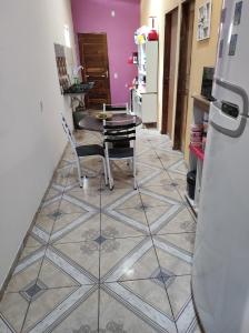 图托亚Recanto dunas的铺有瓷砖地板,设有带桌椅的厨房。
