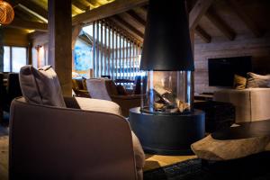 拉克吕萨爱心村社酒店的客厅设有壁炉、椅子和沙发