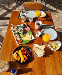 拉斯拉哈斯Magic Mountain Lodge的一张木桌,上面放着食物和橙汁