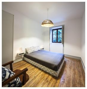阿鲁卡Quinta da Regadas的一间卧室配有一张床和吊灯