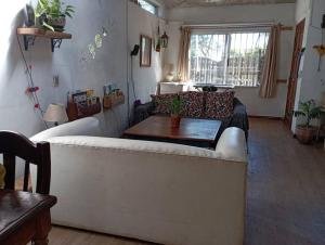 拉弗洛雷斯塔La Floresta的客厅配有白色的沙发和桌子