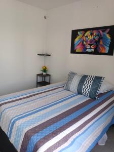 吉拉尔多特AQUAVALE - Apartamento Vacacional en Girardot的卧室配有一张带狮子绘画的床