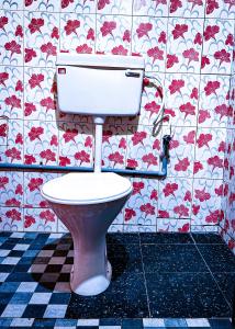 钦纳卡纳Spies Munnar Camping的浴室里设有卫生间,墙上挂着红色的鲜花