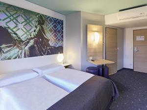 多特蒙德多特蒙德住宿加早餐旅馆的酒店客房设有一张床,墙上挂有绘画作品