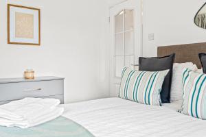 诺丁汉Bramcote Lane Spacious 5 BR House的卧室内的白色床和条纹枕头