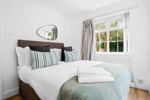 诺丁汉Bramcote Lane Spacious 5 BR House的卧室配有带枕头的大床和窗户。