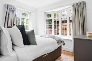 诺丁汉Bramcote Lane Spacious 5 BR House的卧室配有带枕头和窗户的床。
