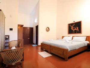 维特利Dhanagiri Home Stay的一间卧室配有一张床和一把椅子