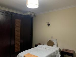 开罗Sheraton apart-hotel的一间卧室配有床、两张桌子和一盏灯。