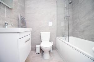 史云顿Kingsbridge Point 4 2 BR with Free Parking的白色的浴室设有卫生间、浴缸和水槽。