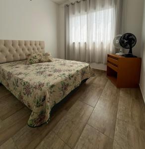 尚格里拉Casa com Piscina em Xangri-Lá RS的一间卧室配有一张床、一个梳妆台和一扇窗户。