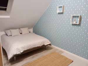 BrévandsLa Salicorne, maison d'hôtes.的一间卧室配有一张蓝色墙壁的床