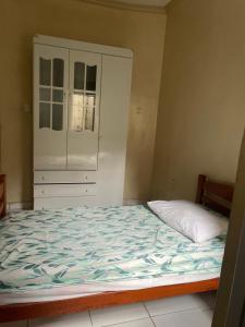 马瑙斯Casa Edgar的一间卧室配有一张大床和一个橱柜