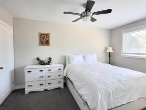滨湖尼亚加拉Cozy Home in Niagara-on-the-Lake的卧室配有白色的床和吊扇