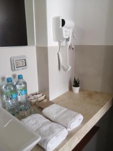 上钦查Casa Yuraq Hotel Boutique的浴室柜台提供毛巾、电话和瓶装水