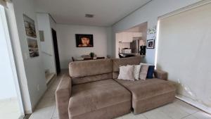 锡诺普Apartamento Confortável e Espaçoso的一间带棕色沙发的客厅和一间厨房